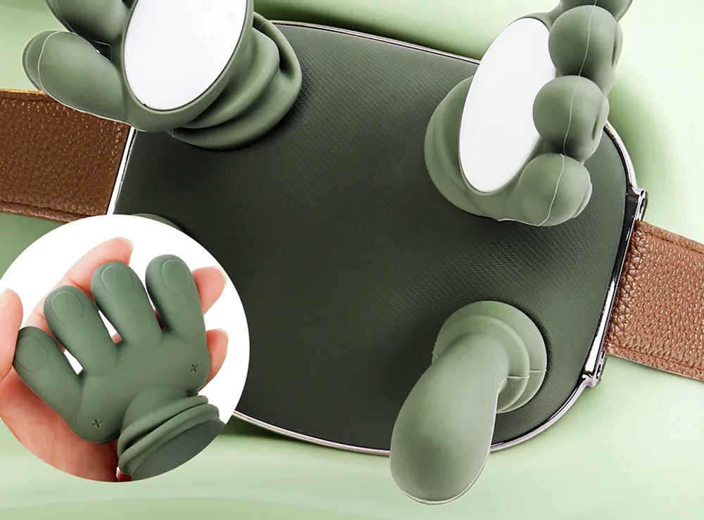 Die Unterseite des Massagegeräts: zwei Silikonhände mit je vier Fingern, die beiden hellen Wärmepads in den Handflächen und zwei Daumen darunter
